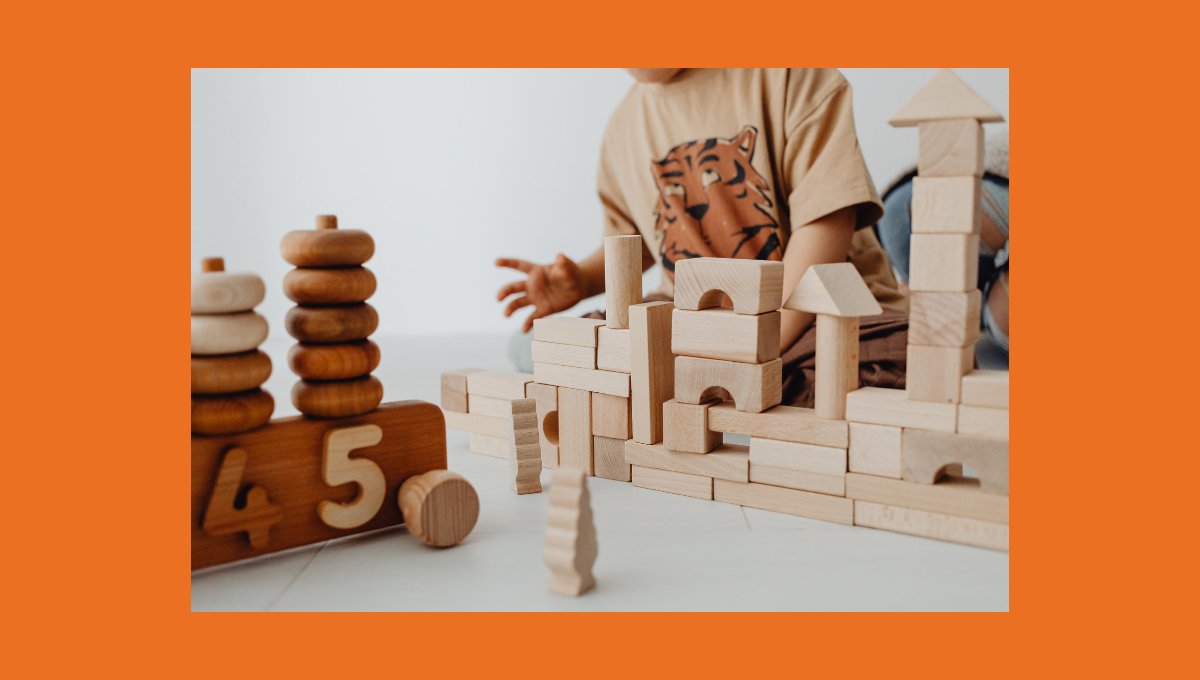 Enfant construisant une tour avec des jeux de construction en bois naturel